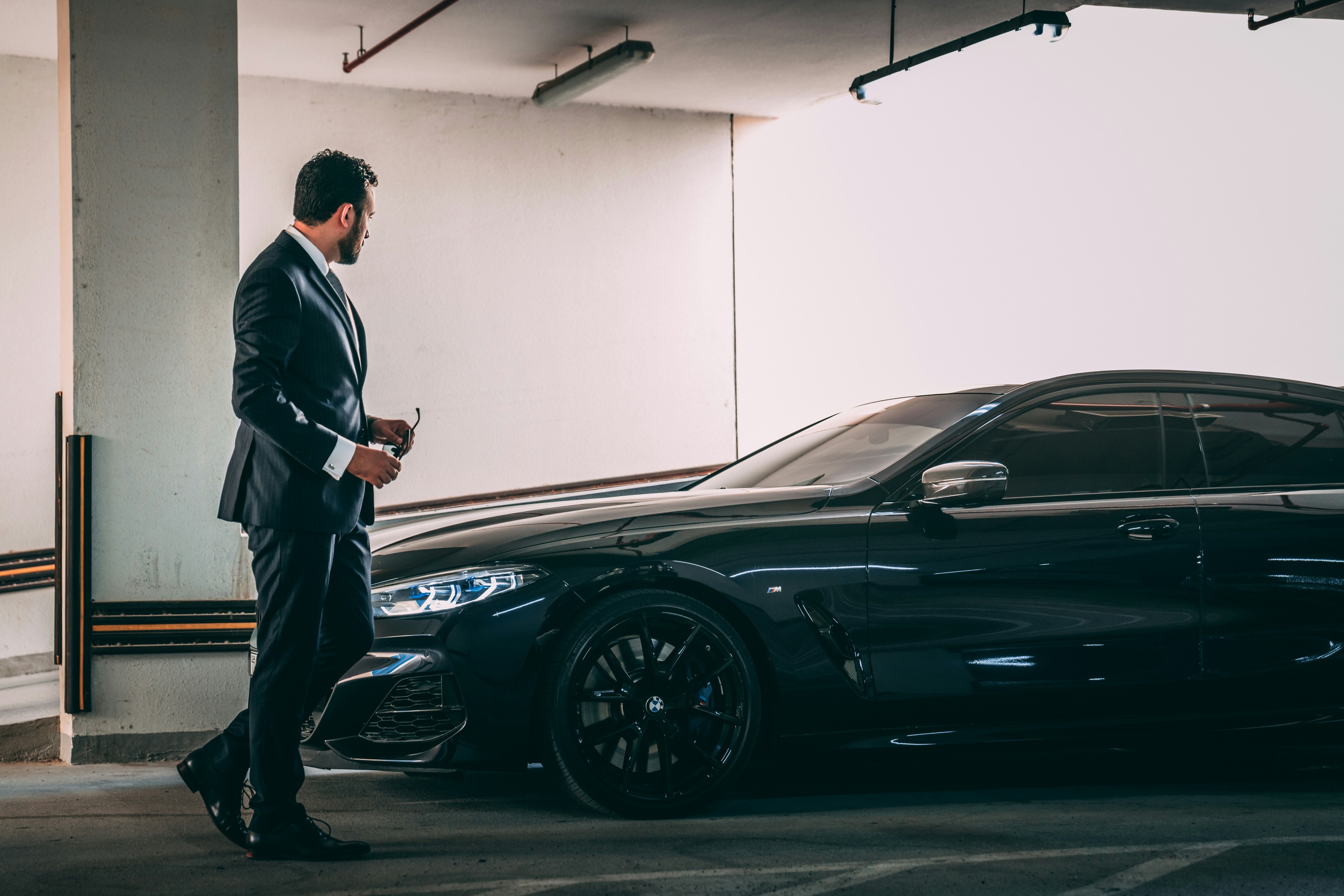 Chauffeur beside a black Mercedes-Benz in a private garage